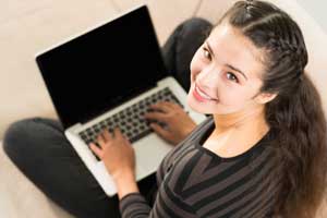 girl smiling up with a laptop in her lap